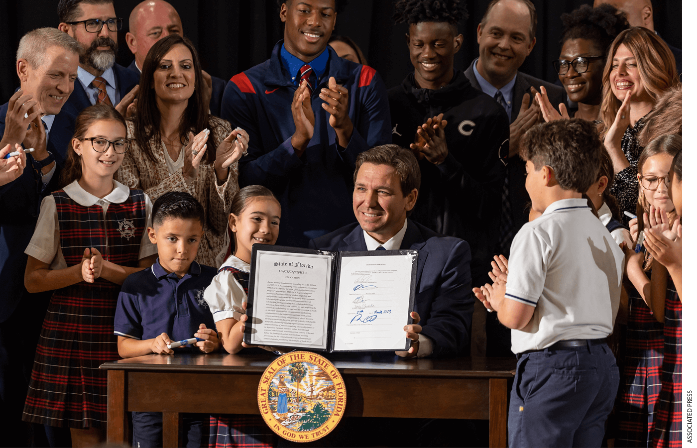 Florida Gov. Ron DeSantis reacts after signing a bill to expand school vouchers across Florida during a press conference at Christopher Columbus High School on Monday, March 27, 2023, in Miami.